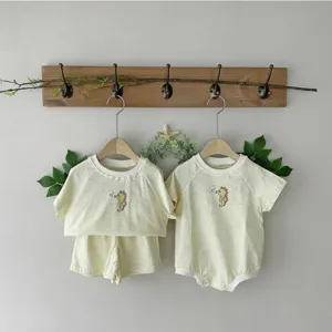 Detailed view of summer baby clothing set with cute seahorse print and striped design.