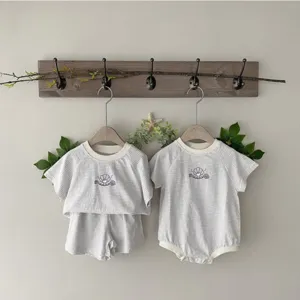 Close up detail of baby summer striped clothing set and romper with cute shell embroidery.