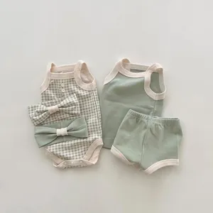 Baby summer tank romper and shorts set detail, cute green plaid infant clothing flat lay.