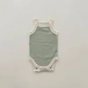 Close-up detail of infant sleeveless tank bodysuit, soft green knit fabric with contrast trim.