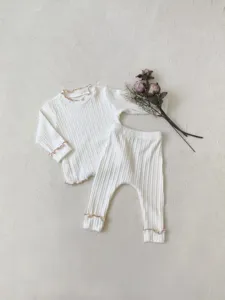 Detailed view of baby girl ribbed long sleeve t-shirt and leggings set with lettuce edge trim.