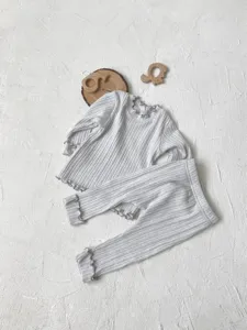 Close-up detail of infant ribbed long-sleeve top and leggings set featuring sweet lettuce trim.