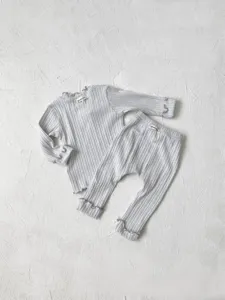 Detailed view of grey ribbed baby long sleeve top and pants set with cute lettuce edges.