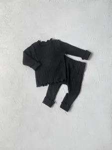 Detailed view of black ribbed baby long sleeve top and pants set, soft knit cotton texture.