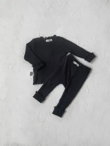Infant black ribbed long sleeve top and matching pants detail, cute lettuce edge design.