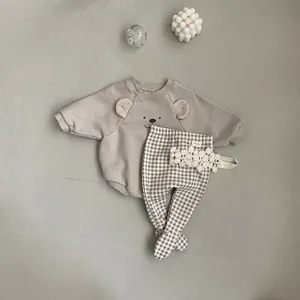 Detailed shot of cute baby bear sweatshirt romper, plaid footed pants and lace headband set.