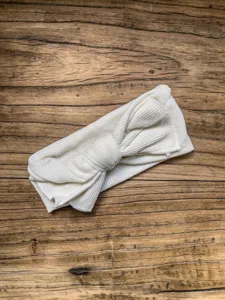 Infant beige knotted ribbed cotton headband detail, soft texture baby hair accessory.