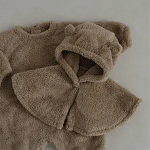 Detalle de mameluco de invierno para bebé de felpa con capa orejas de oso, cálido.