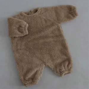 Bebé mameluco peluche grueso cuello redondo invierno, prenda exterior cálida detalle plano.