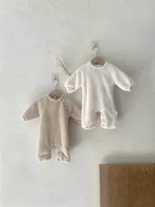 Detalle de mameluco de invierno de felpa para bebé, body suave y cálido colgado.