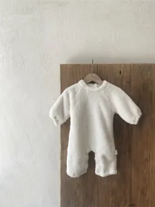 Detalle de mameluco de felpa blanca para bebé, mono de invierno cálido y acogedor.