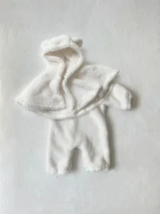 Detalle de mameluco bebé felpa blanca, capucha con orejas de oso, ropa invierno cálida.