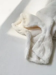 Detalle de pelele de bebé de felpa blanca, textura suave de mameluco de invierno