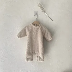Vista detallada del mameluco de bebé de felpa gruesa con cuello redondo en beige, cálido y suave.