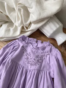 Cute baby girl purple long-sleeve romper with floral embroidery and ruffled collar detail.