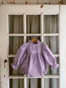 Cute baby girl long sleeve romper with floral embroidery and cute ruffles. Vintage style.