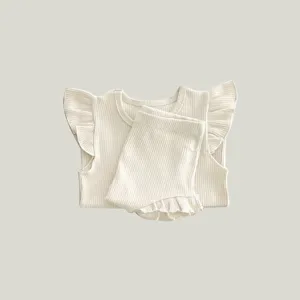 Detail view of cute baby ribbed ruffle top and bloomers set, soft cotton fabric.