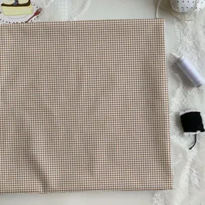 Brown gingham fabric detail view, soft cotton material ideal for DIY sewing, tablecloths.