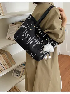 Vista detallada de bolso tote negro arrugado con bordado blanco y dije de nube tierno.