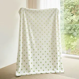 Vista detallada de una acogedora manta de franela blanca con un bonito diseño de estrellas.
