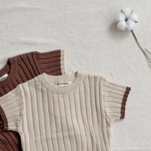 Vue détaillée du pull court pour bébé en tricot à bordure contrastée, tissu doux et confortable.