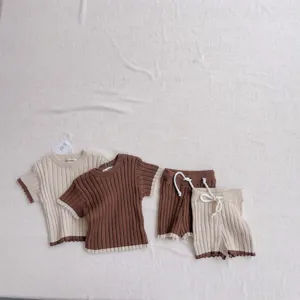 Détail tricot côtelé bébé avec bordure couleur contrastée pull manches courtes short.