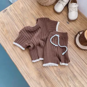 Vue détaillée ensemble pull en tricot bébé manches courtes short avec bordure contrastée.