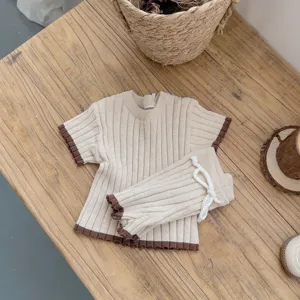 Ensemble pull et short tricot pour bébé, haut manches courtes doux et short avec bordure.