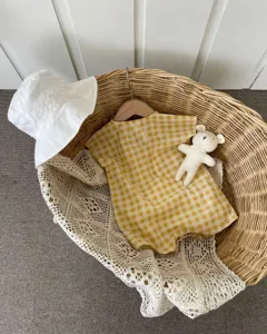 Detailed view of lightweight cotton baby romper in yellow check, cute summer infant onesie.