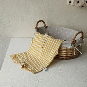 Close-up detail of yellow-white gingham baby romper, sleeveless summer infant cotton apparel.