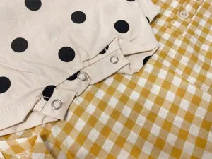 Infant baby summer sleeveless polka dot romper detail view with metal snap buttons top.