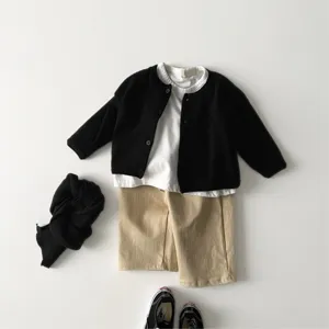 Details of the baby black knit cardigan and white t-shirt outfit set, cozy and soft fabric.