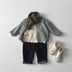 Flat lay detail shot of baby cardigan set, ribbed knit texture, minimalist style background.