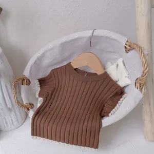 Détail de pull en tricot pour bébé, haut côtelé marron avec bordure contrastée mignonne.