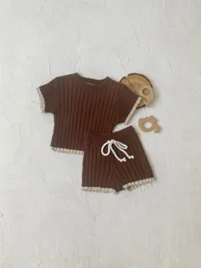 Ensemble pull tricoté et short pour bébé à manches courtes avec bordure contrastée et jouets.
