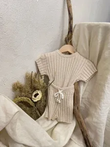 Ensemble de tricot pour bébé avec pull à manches courtes côtelé et short assorti.