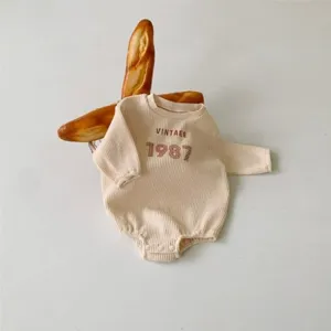 Infant waffle romper featuring cute vintage 1987 print, soft long sleeve baby bodysuit for spring.