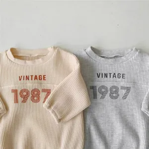 Infant waffle knit long sleeve romper with vintage 1987 digital print design for baby daily wear.