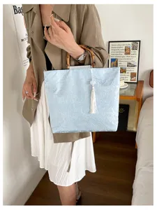 Detailansicht der lässigen minimalistischen großen Damentasche mit blauem Blumenstoff und Bambusgriff.