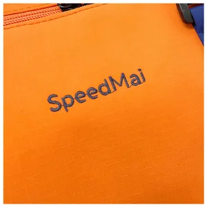 Détail de sac de voyage orange, tissu ripstop résistant, bagage de sport extérieur étanche.