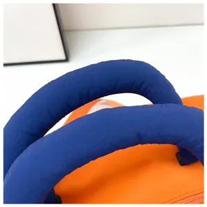 Gros plan de la poignée bleue et du sac de voyage orange pour le sport et le fitness.