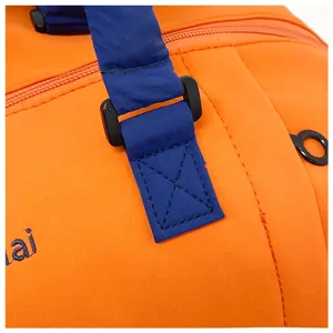 Vue détaillée de la sangle de sac de voyage orange, coutures renforcées et boucles durables.