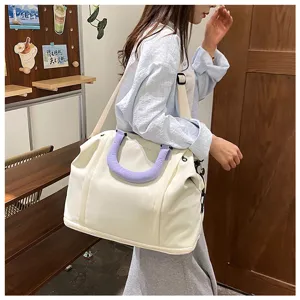 Grand sac de voyage de grande capacité avec poignée violette et bandoulière pour courts trajets.