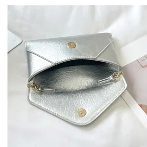 Silver metallic envelope shoulder bag for women, stylish crossbody bag with chain strap.