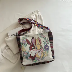 Gewebte Segeltuch-Umhängetasche mit süßem Cartoon-Kaninchen- und Blumenmuster für den Alltag.