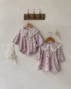 Detailed view of baby girls floral long-sleeve dress and romper set with delicate lace collar.