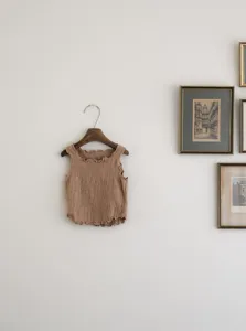 Details of the kids solid color crinkled cotton tank top with cute wave rolled edge design.