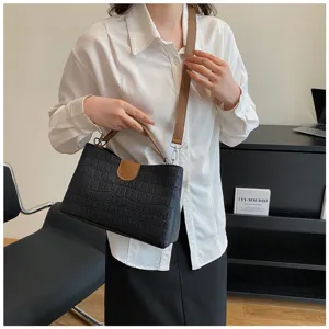 Detailed view of the black crocodile pattern crossbody shoulder handbag with brown strap.
