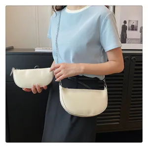 Detail shot of women minimalist half moon shoulder bag, stylish chain strap hobo purse.
