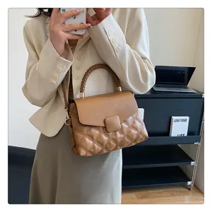 Detailed view of stylish brown quilted shoulder bag featuring trendy braided handle and chic flap.